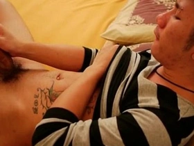 An Asian gay masturbates in bed.